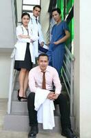 sur este asiático joven malayo chino hombre mujer médico médico estetoscopio delantal grupo estar actitud confidente foto