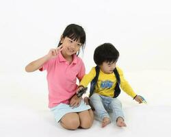 south East Asian brother sister child playing posing on white background photo