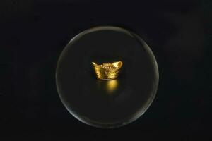 gold ingot money through glass crystal ball photo