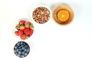 Blueberry Strawberry Herb Spice Almond Cashew Nut Mandarin Orange in bowl on white background photo