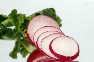 Small red radish on white reflection ackground photo