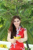 Young south east asian Chinese man woman traditional costume Chinese new year greeting outdoors at temple photo