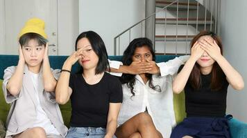 joven asiático mujer grupo gracioso No oler ver hablar escucha creer mano firmar en azul vivo habitación sofá Tres sabio mono foto