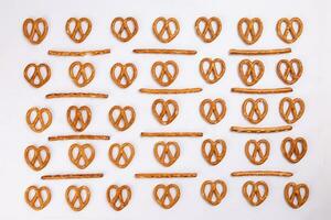 Pretzel cracker sticks laid in rows design angle straight on what background photo