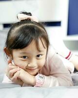 One girl children lying on bed looking forward posing photo