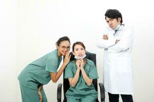 Young asian malay chinese male female doctor sit on chair stand gossip annoyed photo