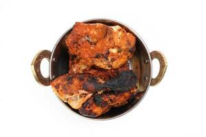 Spicy red Chicken grilled tikka tandoori in metal brass copper pot on white background photo