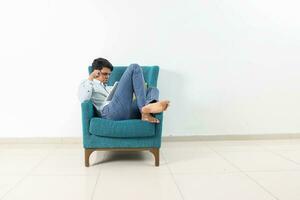 A young south east Asian sit pose look think work study emotion feelings on a blue single sofa. He is adhd and autistic photo