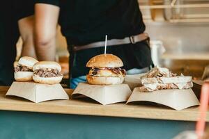 Burgers at a burger feast. Dinner Hamburger Food Feast Party. Big burger at street food outdoor festival. Festival food day photo