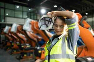 Portrait of female engineer with the mission of auditing, testing, improving software and calibrating robotics arm. photo