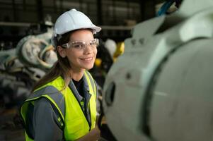 In the robots warehouse, Female engineer happily with updating software and calibrating a robotics arm. photo