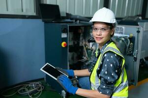 Female Technician Inspecting and repairing robotics arm in robots hangar and test the operation of the machine after being used for a while, as well as updating the software and calibration photo