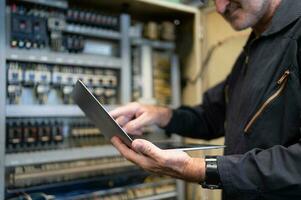 mayor ingeniero inspecciona el eléctrico sistema y refacción el mecánico sistema en el máquina controlar gabinete. en orden para el máquina a regreso a normal operación foto