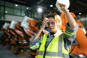 Portrait of female engineer with the mission of auditing, testing, improving software and calibrating robotics arm. photo