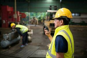 The technician team leader encourages the team who are tired from hard work. in repairing old machinery to return to normal operation in the company's old machinery warehouse photo