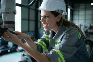 hembra técnico inspeccionando y reparando robótica brazo en robots hangar y prueba el operación de el máquina después siendo usado para un mientras, como bien como actualización el software y calibración foto