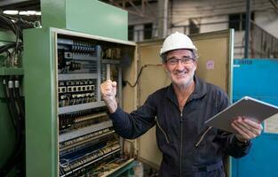 mayor ingeniero inspecciona el eléctrico sistema y refacción el mecánico sistema en el máquina controlar gabinete. en orden para el máquina a regreso a normal operación foto