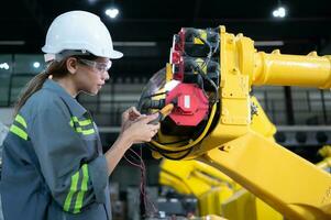 In the robots warehouse, A female engineer inspects the electrical system of every robotics arm, before delivering to the customer. photo