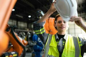 Portrait of female engineer with the mission of auditing, testing, improving software and calibrating robotics arm. photo