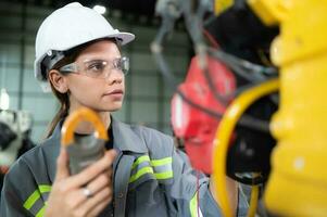 In the robots warehouse, A female engineer inspects the electrical system of every robotics arm, before delivering to the customer. photo