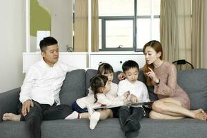 Parents Child Family father mother daughter son sit on sofa reading writing study teaching photo