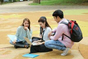 joven asiático malayo chino hombre mujer al aire libre parque libro archivo carpeta ordenador portátil computadora teléfono sentar estar estudiar mezclarse foto