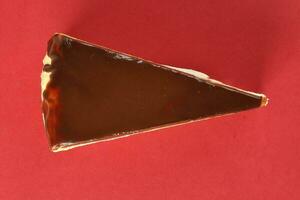 Chocolate crepe layer cake slice top view red background photo