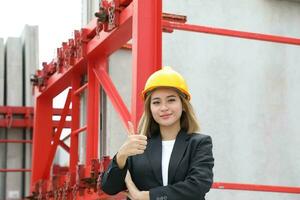 asiático mujer chino malayo trabajador ingeniero administración difícil sombrero la seguridad casco a construcción sitio pulgares arriba foto