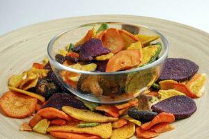 Healthy vegetable chips yellow sweet potato purple sweet potato carrot green radish green beans and shiitake mushrooms photo