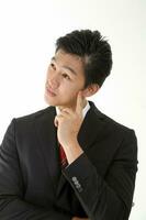 South East Asian young Chinese man wearing formal business office ware on white pose hand on cheek photo