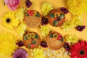 Colorful flower decorated moon cake Chinese mid autumn festival daisy chrysanthemum mum rose baby breath flower red yellow pink purple violet on yellow background photo