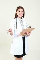 joven asiático hembra médico vistiendo delantal uniforme sayo delantal sostener foto