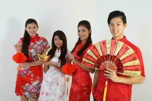 sur este asiático joven malayo chino indio hombre mujer vistiendo tradicional chino cheongsam vestir en blanco antecedentes tienda intercambiar regalo naranja saludos compartir racial unidad armonía mano ventilador foto