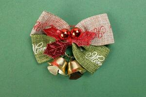 Small Christmas xmas gift bow ribbon Pine Arrangement bell on green background copy text space photo