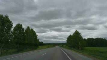 novosibirsk, Rusia junio 23, 2021 - pov desde el frente ventana de el coche sobre el la carretera. vehículo punto de vista, conducción a lo largo país autopista video