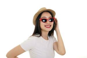 Beautiful young south east Asian woman wearing red frame sunglass eyewear hat pose fashion style white background look around copy text space photo