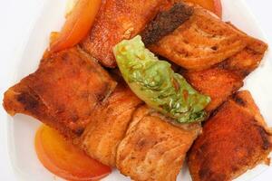 Pan friend salmon fish fillet in white plate on white background photo