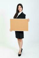 One young Asian Malaysian business office woman holding blank copy text space sign board on white background photo