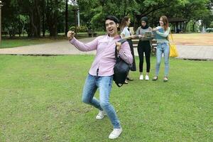 joven asiático malayo chino hombre mujer al aire libre parque libro archivo carpeta ordenador portátil computadora teléfono sentar estar estudiar mezclarse foto