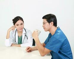 Young Asian male female doctor wearing apron uniform stethoscope female patient talk discuss cheek photo