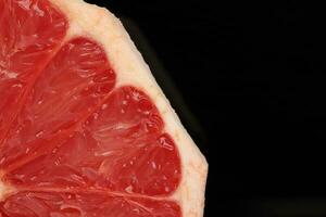 Ruby red grapefruit closeup macro pulp on black background photo