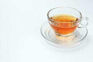 Clear licker tea in a transparent glass cup saucer spoon on white background photo