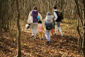 Mother with kids in family leisure at autumn activity in forest. photo