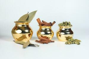 Cardamom cinnamon bay leaf spice in shiny metal pot photo