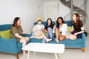 Young Asian woman group talk gossip chat sing party fun enjoy emotion on blue living room sofa photo