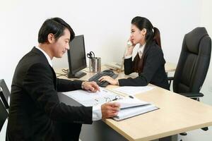 Young Asian man woman wearing business office suit chair table computer white background photo