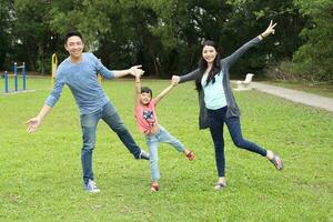 Southeast Asian multigeneration family parents daughter grandmother father mother child pose happy sit stand  outdoor park photo