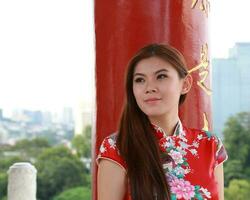 Young south east asian Chinese man woman traditional costume Chinese new year greeting outdoors at temple photo