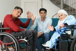 Portrait of young man and woman talking discussing work business. Two on wheelchair are paralyzed and one sitting on sofa adhd also Autism autistic photo