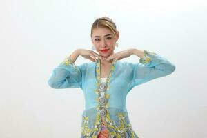 Asian woman traditional blue orange kebaya sharong on white  background hand on cheek pose photo